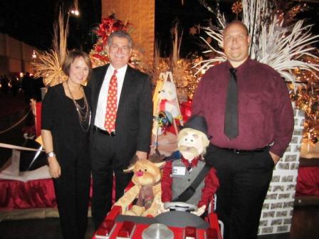 goodwins-and-friends Children's Hospital CEO Keith Goodwin with his wife, Diane, and hospital employee Mike Cooper, right. Cooper purchased the remote control "Sketch" character with his own money and volunteers to operate it at events like this. (Its head is interchangeable. Sometimes it's a doctor!)