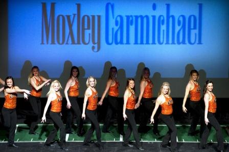 ut-dance-team Moxley Carmichael staff members. Ha. Just kidding. It's the UT dancers at the pep rally for "Extreme Makeover: Home Edition." Our sponsor logo just happened to be behind them when our buddy Saul Young of the News Sentinel shot this pic.