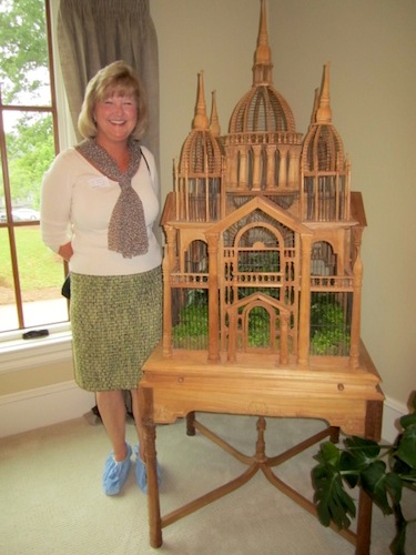 aviary Designer Carol Hudson poses by the aviary featured in yet another bedroom which she furnished in the house.