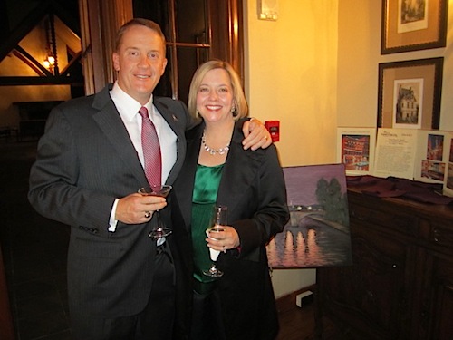 nystroms Hugh and Angelia pose in front of a Mike C. Berry painting that was to be in the live auction. Hugh is director of program operations and development for Childhelp Tennessee.