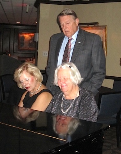 singing Carolyn and Ron Lawrence join pianist Joy Cox for a song.