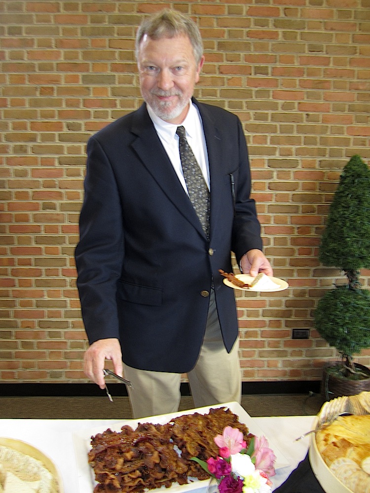 Clarence Brown Theatre Artistic Director Cal MacLean trying some candied bacon, a trademark of caterer Holly Hambright.