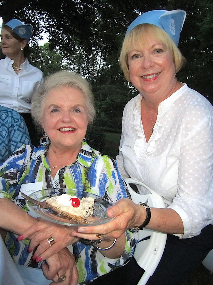 Host Jeannie Dulaney serving Dawn Ford dessert.