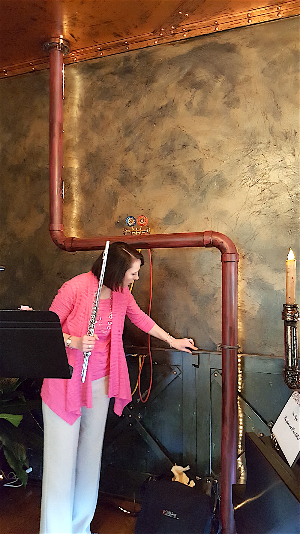 Rachel Ford, executive director of the Knoxville Symphony, takes a break from performing to examine the "Steampunk" design in the Music Room by William Bell.