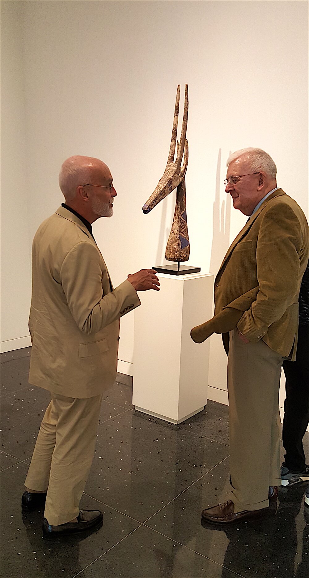 John Cotham, left, and Terry Wertz in front of a headdress in the form of an antelope.