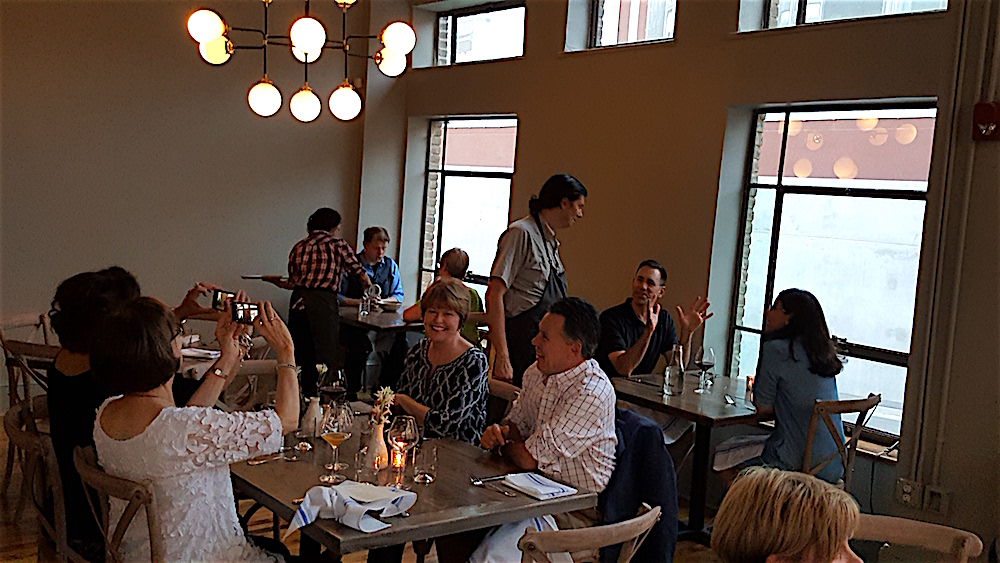 Chef Lenn, standing, greeting guests in the large back dining room.