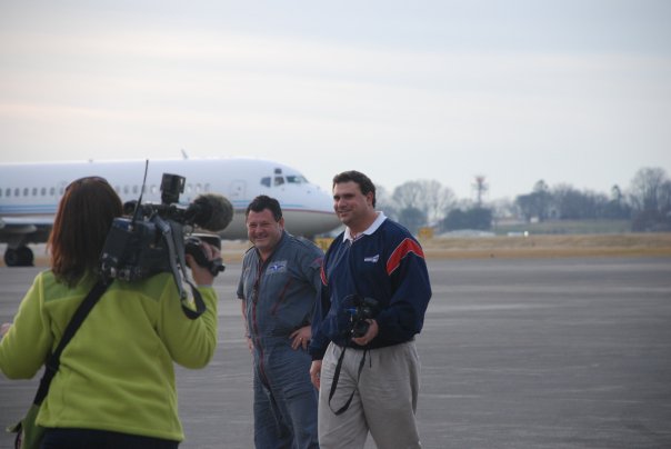 Reporter Erin Donovan shoots video of Russell Biven, right, and pilot Adrian Van Zyl, who flew the ProVision plane