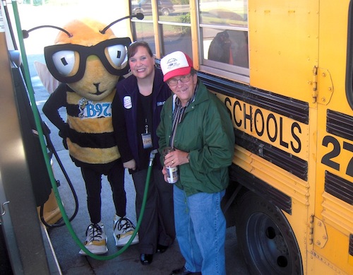 buzzbee-jennifer-alexander-james-hurst Buzz Bee and Jennifer Alexander of B-97.5 fill up a school bus for James Hurst at the Pilot on East Emory Road.
