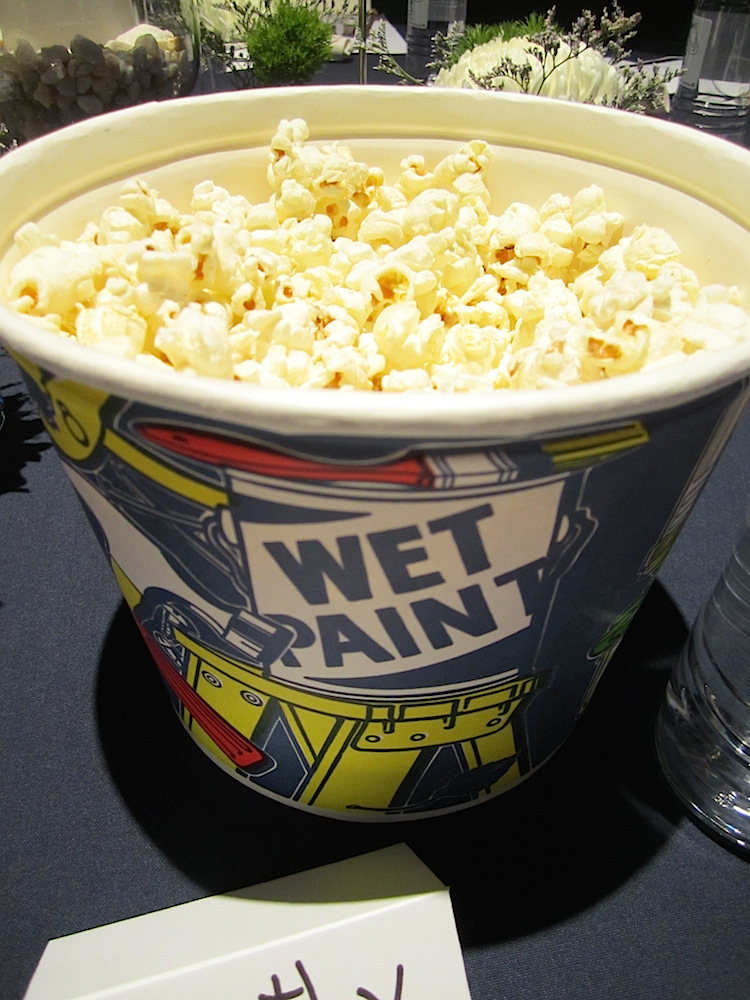 Paint buckets filled with popcorn were on each table.