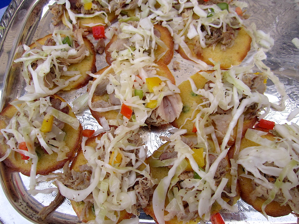 Corn cakes topped with slow slaw and pork confit.