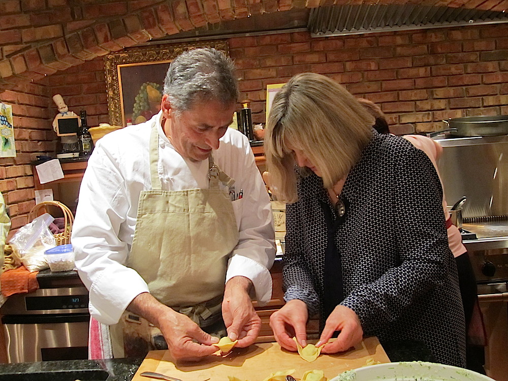 Chef shows Sylvia how to fold ravioli.