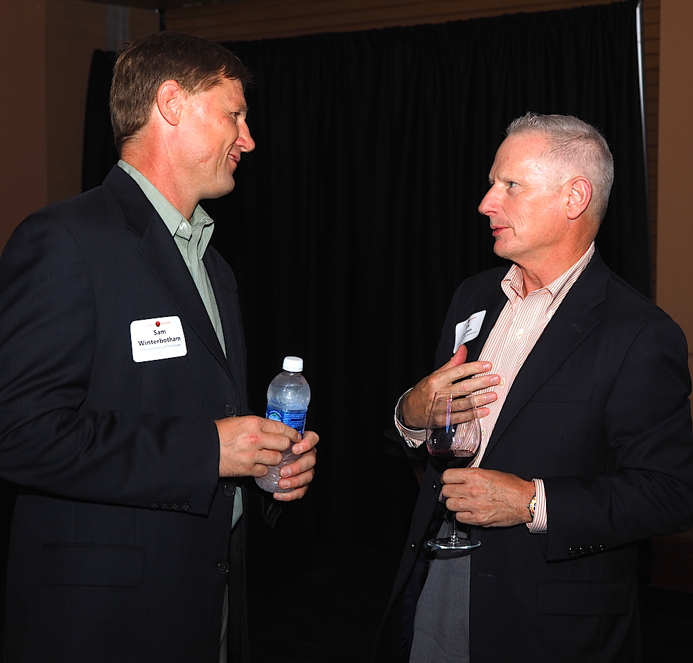Sam Winterbotham, UT tennis coach, left, talks with Jim Clayton of Scripps Networks Interactive. (Photo by Gary Heatherly.)