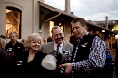 Bruce McCamish, right, shows some pictures to Margot Kline and Brooks Clark. (Photo by David Andrews.)