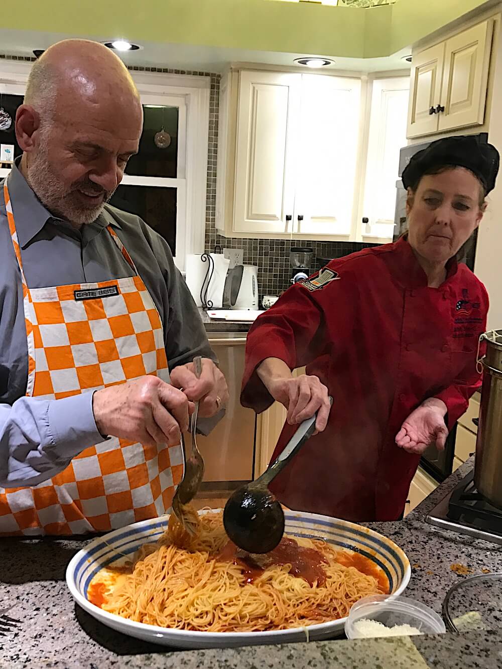 While Dr. Joe tossed the pasta, Sarah Kiely of the UT Culinary Institute added more sauce.